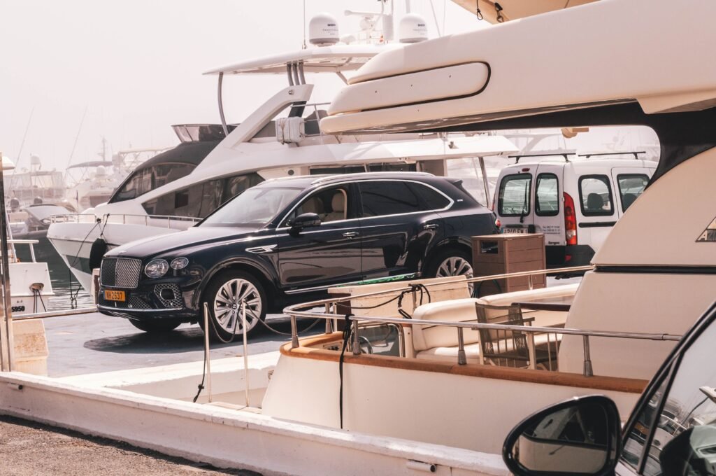 Luxury SUV parked beside yachts in a marina