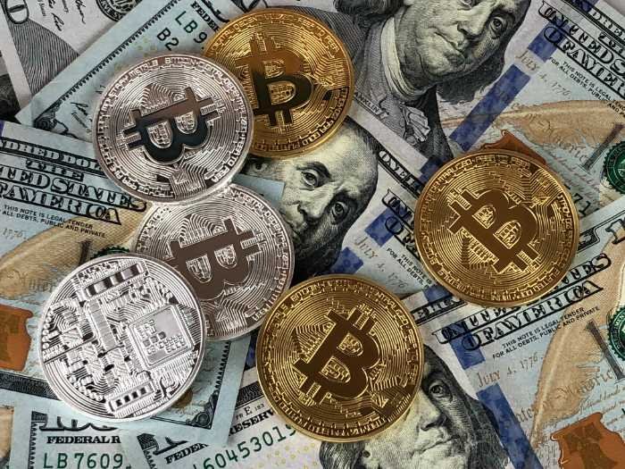 Bitcoin coins on US dollar banknotes