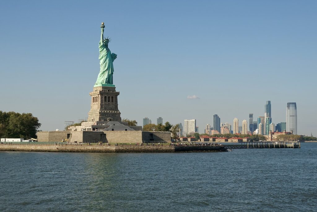 Statue of Liberty on Liberty Island, with Ellis Island and Jersey City behind