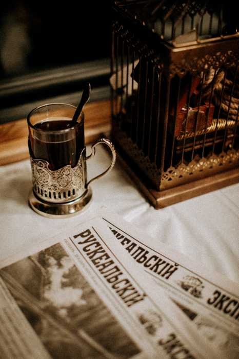 Glass of tea in a metal holder on Russian newspapers