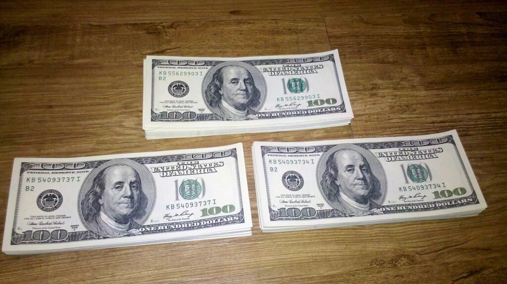 Stacks of US 100-dollar bills on a wooden table